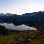 Person standing on top of Tjeldbergtinden, overlooking the lake Stor Kongsvatnet.