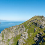 Nordlandsnupen summit on Værøy, with ocean and Mosken island in the background.