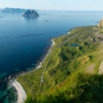 View from Hornet over Nordlandshagen and old airstrip on Værøy, with Mosken and Lofoten islands in the distance